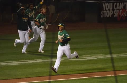 Sep 9, 2020; Oakland, California, USA; Oakland Athletics designated hitter Tommy La Stella (3) scores a walk-off run as players leave the dugout to celebrate with batter, center fielder Ramon Laureano (not pictured), during the ninth inning against the Houston Astros at Oakland Coliseum. Mandatory Credit: Kelley L Cox-USA TODAY Sports