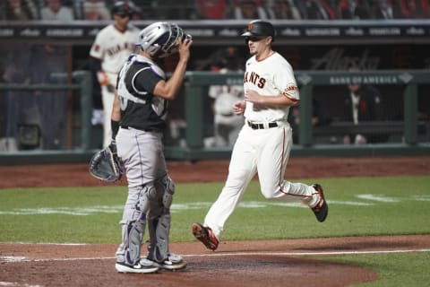 Sep 23, 2020; San Francisco, California, USA; San Francisco Giants left fielder Alex Dickerson (right) scores against Colorado Rockies catcher Elias Diaz (left) during the fifth inning at Oracle Park. Mandatory Credit: Kyle Terada-USA TODAY Sports