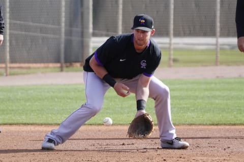 Feb 26, 2021; Scottsdale, Arizona, USA; Colorado Rockies second baseman Ryan McMahon (24) fields the ball during spring training at Salt River Fields. Credit: Rick Scuteri-USA TODAY Sports