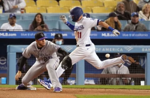 Apr 13, 2021; Los Angeles, California, USA; Los Angeles Dodgers left fielder AJ Pollock (11) reaches first base safely before the throw to Colorado Rockies first baseman C.J. Cron (25) on a single during the fifth inning at Dodger Stadium. Mandatory Credit: Kirby Lee-USA TODAY Sports