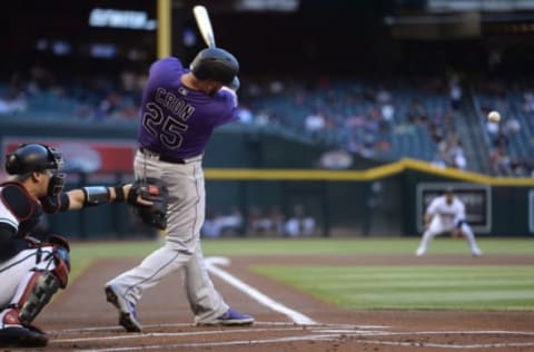 Apr 30, 2021; Phoenix, Arizona, USA; Colorado Rockies first baseman C.J. Cron (25) hits an RBI single against the Arizona Diamondbacks during the first inning at Chase Field. Mandatory Credit: Joe Camporeale-USA TODAY Sports