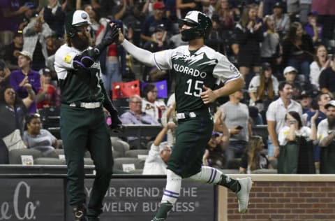 Jun 4, 2022; Denver, Colorado, USA; Colorado Rockies right fielder Randal Grichuk (15) high fives designated hitter Charlie Blackmon (19) after scoring against the Atlanta Braves in the 10th inning at Coors Field. Mandatory Credit: John Leyba-USA TODAY Sports