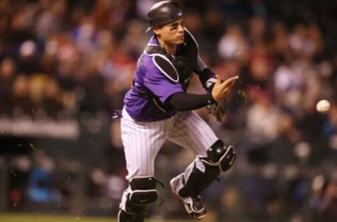 Apr 24, 2017; Denver, CO, USA; Colorado Rockies catcher Tony Wolters (14) fields a ground ball during the eighth inning against the Washington Nationals at Coors Field. The Rockies won 8-4. Mandatory Credit: Chris Humphreys-USA TODAY Sports