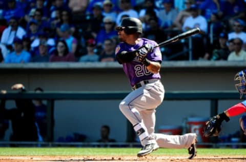 Mar 11, 2017; Mesa, AZ, USA; Colorado Rockies first baseman Ian Desmond (20) singles in the first inning against the Chicago Cubs during a spring training game at Sloan Park. Mandatory Credit: Matt Kartozian-USA TODAY Sports