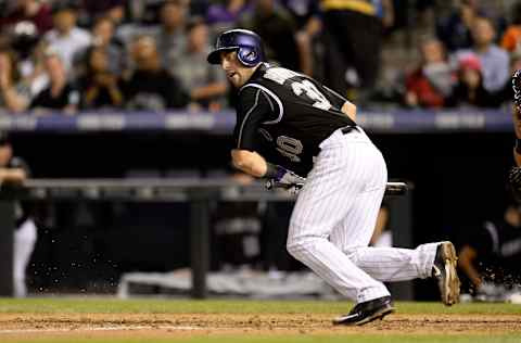 Sep 23, 2015; Denver, CO, USA; Colorado Rockies catcher Tom Murphy (30) singles on a bunt in the fourth inning against the Pittsburgh Pirates at Coors Field. Mandatory Credit: Ron Chenoy-USA TODAY Sports