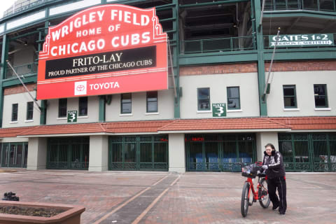 CHICAGO, ILLINOIS – MARCH 26: A woman pushes her bike in front of Wrigley Field on what was to be opening day for Major League Baseball on March 26, 2020 in Chicago, Illinois. Major League Baseball has postponed the start of its season indefinitely due to the coronavirus (COVID-19) outbreak. (Photo by Scott Olson/Getty Images)