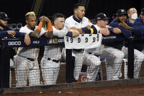 SAN DIEGO, CALIFORNIA – OCTOBER 13: Martin Maldonado #15, Alex Bregman #2 and Carlos Correa #1 of the Houston Astros look on from the dugout during the ninth inning against the Tampa Bay Rays in Game Three of the American League Championship Series at PETCO Park on October 13, 2020 in San Diego, California. (Photo by Harry How/Getty Images)