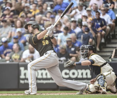 Aug 4, 2021; Milwaukee, Wisconsin, USA; Pittsburgh Pirates catcher Jacob Stallings (58) hits a one-run RBI double as Milwaukee Brewers catcher Manny Pina (9) watches in the fourth inning at American Family Field. Mandatory Credit: Benny Sieu-USA TODAY Sports