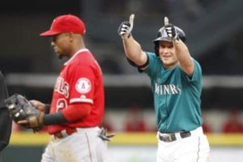 Jul 10, 2015; Seattle, WA, USA; Seattle Mariners third baseman Kyle Seager (15) reacts to the bench after hitting double in the first inning as Los Angeles Angels shortstop Erick Aybar (2) walks to the mound at Safeco Field. Mandatory Credit: Jennifer Buchanan-USA TODAY Sports