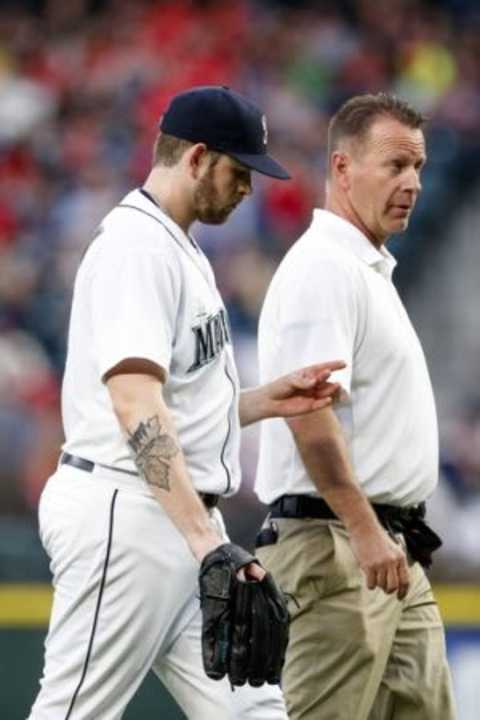 May 28, 2015; Seattle, WA, USA; Seattle Mariners pitcher James Paxton (65) walks back to the dugout with a team staff member after being relieved because an injury during the fifth inning against the Cleveland Indians at Safeco Field. Mandatory Credit: Joe Nicholson-USA TODAY Sports