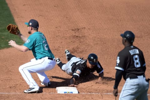 Mar 25, 2016; Peoria, AZ, USA; Chicago White Sox third baseman Tyler Saladino (18) dives back to first as Seattle Mariners first baseman Adam Lind (26) awaits the throw during the seventh inning at Peoria Sports Complex. Mandatory Credit: Jake Roth-USA TODAY Sports