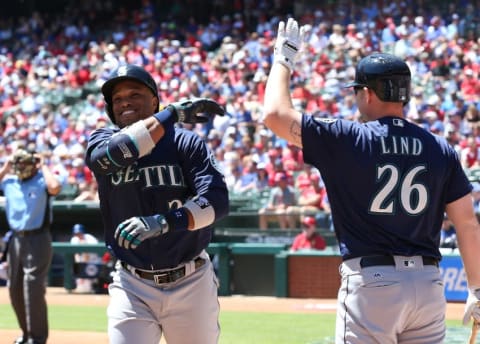 Apr 6, 2016; Arlington, TX, USA; Seattle Mariners second baseman Robinson Cano (22) celebrates a two run home run with first baseman Adam Lind (26) in the first inning against the Texas Rangers at Globe Life Park in Arlington. Mandatory Credit: Matthew Emmons-USA TODAY Sports