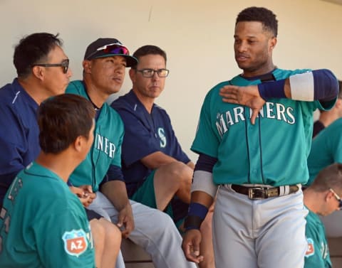 Mar 27, 2016; Mesa, AZ, USA; Seattle Mariners second baseman Robinson Cano (R) talks to first baseman Dae-Ho Lee (L) in the dugout during the fourth inning against the Chicago Cubs at Sloan Park. Mandatory Credit: Jake Roth-USA TODAY Sports