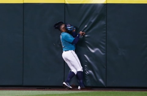 Apr 29, 2016; Seattle, WA, USA; Seattle Mariners center fielder Leonys Martin (12) hits the wall after catching the final out to defeat the Kansas City Royals 1-0 at Safeco Field. Mandatory Credit: Joe Nicholson-USA TODAY Sports