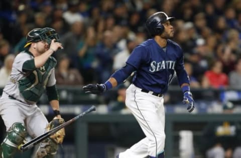 Oct 1, 2016; Seattle, WA, USA; Seattle Mariners second baseman Robinson Cano (22) drops his bat as he watches his two-run home run leave the park as Oakland Athletics catcher Stephen Vogt (21) looks on during the fifth inning at Safeco Field. Mandatory Credit: Jennifer Buchanan-USA TODAY Sports