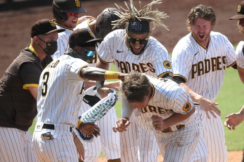 SAN DIEGO, CALIFORNIA – AUGUST 27: Manny Machado #13, Fernando Tatis Jr. #23, Eric Hosmer #30, and Jorge Mateo #3 congratulate Wil Myers #4 of the San Diego Padres after his walkoff three-run homerun during the seventh inning of a double header to defeat the Seattle Mariners 10-7at PETCO Park on August 27, 2020 in San Diego, California. Several sporting leagues across the nation are resuming their schedules after player walkouts done in protest over the shooting of Jacob Blake by Kenosha, Wisconsin police (Photo by Sean M. Haffey/Getty Images)