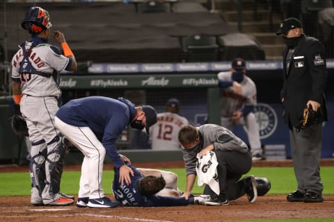 SEATTLE, WASHINGTON – SEPTEMBER 21: Dylan Moore #25 of the Seattle Mariners is attended to after being hit by pitch in the eighth inning against the Houston Astros at T-Mobile Park on September 21, 2020 in Seattle, Washington. (Photo by Abbie Parr/Getty Images)