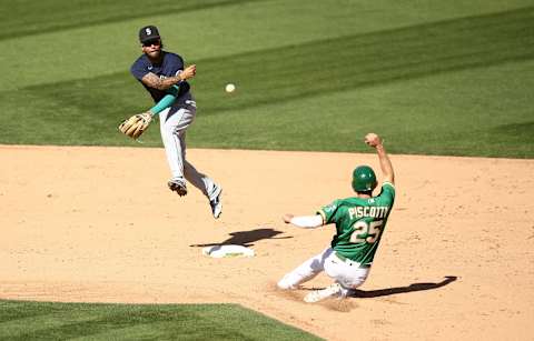 OAKLAND, CALIFORNIA – SEPTEMBER 26: J.P. Crawford of the Seattle Mariners turns an acrobatic double play.  Avengers. (Photo by Ezra Shaw/Getty Images)