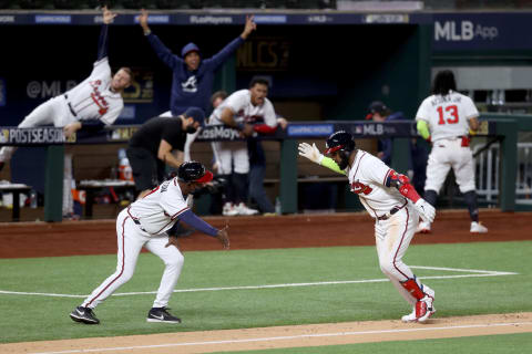 ARLINGTON, TEXAS – OCTOBER 15: Marcell Ozuna #20 of the Atlanta Braves celebrates with third base coach Ron Washington after hitting a solo home run against the Los Angeles Dodgers during the seventh inning in Game Four of the National League Championship Series at Globe Life Field on October 15, 2020 in Arlington, Texas. (Photo by Tom Pennington/Getty Images)