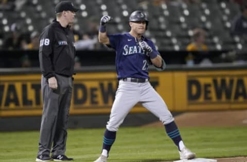 OAKLAND, CALIFORNIA – SEPTEMBER 21: Dylan Moore #25 of the Seattle Mariners standing on third celebrates after hitting a two-run RBI triple against the Oakland Athletics in the top of the fourth inning at RingCentral Coliseum on September 21, 2021 in Oakland, California. (Photo by Thearon W. Henderson/Getty Images)