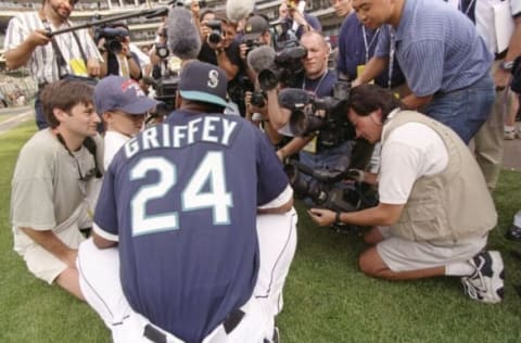 8 Jul 1997: Center fielder Ken Griffey Jr. of the Seattle Mariners kneels with reporter during the MLB All-Star Game at Jacobs Field in Cleveland, Ohio. Mandatory Credit: Jed Jacobsohn /Allsport