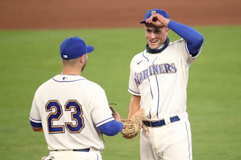 SEATTLE, WASHINGTON – SEPTEMBER 06: Evan White #12 and Ty France #23 of the Seattle Mariners have a conversation between the top and bottom of the eighth inning against the Texas Rangers at T-Mobile Park on September 06, 2020, in Seattle, Washington. (Photo by Abbie Parr/Getty Images)