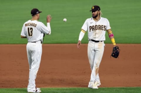 ARLINGTON, TEXAS – OCTOBER 08: Fernando Tatis Jr. of the San Diego Padres tosses the ball to Manny Machado. (Photo by Tom Pennington/Getty Images)