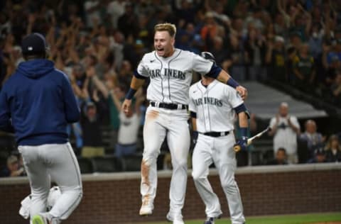 SEATTLE, WASHINGTON – JULY 24: Jarred Kelenic #10 of the Seattle Mariners celebrates with teammates after scoring on a Oakland Athletics wild pitch to end the game in the ninth inning at T-Mobile Park on July 24, 2021 in Seattle, Washington. The Seattle Mariners won 5-4. (Photo by Alika Jenner/Getty Images)