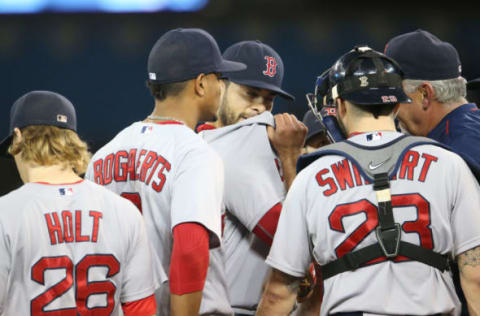 TORONTO, CANADA – SEPTEMBER 19: Noe Ramirez of the Boston Red Sox is visited on the mound by pitching coach Carl Willis and his teammates. (Photo by Tom Szczerbowski/Getty Images)