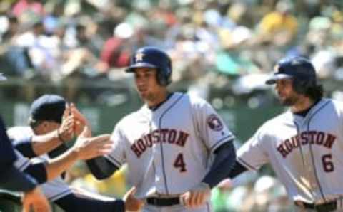 Jul 20, 2016; Oakland, CA, USA; Houston Astros right fielder George Springer (4) and center fielder Jake Marisnick (6) are greeted in the dugout after scoring on a base hit by shortstop Carlos Correa (not pictured) in the eighth inning of their MLB baseball game at Oakland Coliseum. Mandatory Credit: Lance Iversen-USA TODAY Sports