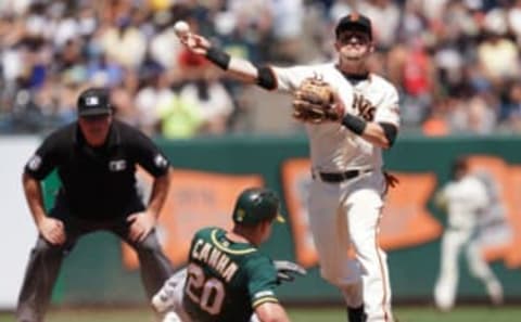 SAN FRANCISCO, CA – AUGUST 14: Scooter Gennett #14 of the San Francisco Giants completes the double-play throwing over the top of Mark Canha #20 of the Oakland Athletics in the top of the fifth inning at Oracle Park on August 14, 2019, in San Francisco, California. (Photo by Thearon W. Henderson/Getty Images)