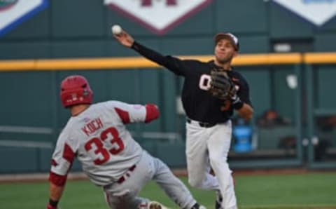 Omaha, NE – JUNE 26: Infielder Nick Madrigal #3 of the Oregon State Beavers turns a double play with a throw to first over catcher Grant Koch #33 of the Arkansas Razorbacks in the third inning during game one of the College World Series Championship Series on June 26, 2018, at TD Ameritrade Park in Omaha, Nebraska. (Photo by Peter Aiken/Getty Images)