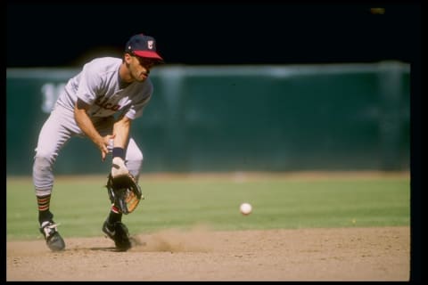 Shortstop Ozzieuillen of the Chicago White Sox reaches down to scoop up the ball.