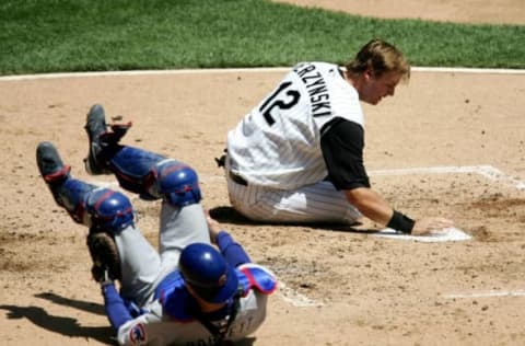 CHICAGO – MAY 20: A.J. Pierzynski #12 of the Chicago White Sox slaps home base after colliding with Michael Barrett #8 of the Chicago Cubs on a sacrifice fly in the second inning on May 20, 2006 at U.S. Cellular Field in Chicago, Illinois. (Photo by Jonathan Daniel/Getty Images)