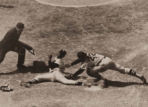 Minnie Minoso (L) of the Chicago White Sox slides around Boston catcher Sammy White in a 1953 game. (Photo by Mark Rucker/Transcendental Graphics, Getty Images)