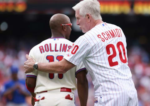 Jun 14, 2014; Philadelphia, PA, USA; Philadelphia Phillies shortstop Jimmy Rollins (11) hits a single to right in the fifth inning to become the all time franchise hit leader and is congratulated by former record holder Mike Schmidt during a game against the Chicago Cubs at Citizens Bank Park. Mandatory Credit: Bill Streicher-USA TODAY Sports