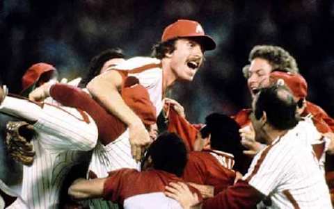 1980 World Series MVP and Phillies Hall of Famer Mike Schmidt jumps atop a group of celebrating teammates as the Phils win the first World Series in franchise history. (Photo Credit: Philadelphia Daily News/Joe McLaughlin)