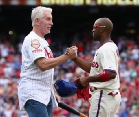 Jun 14, 2014; Philadelphia, PA, USA; Philadelphia Phillies shortstop Jimmy Rollins (11) hits a single to right in the fifth inning to become the all time franchise hit leader and is congratulated by former record holder Mike Schmidt during a game against the Chicago Cubs at Citizens Bank Park. Mandatory Credit: Bill Streicher-USA TODAY Sports