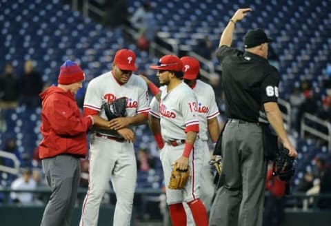 Apr 28, 2016; Washington, DC, USA; Philadelphia Phillies relief pitcher Dalier Hinojosa (94) is tended to by the trainer after suffering an apparent wrist injury against the Washington Nationals during the eighth inning at Nationals Park. Mandatory Credit: Brad Mills-USA TODAY Sports