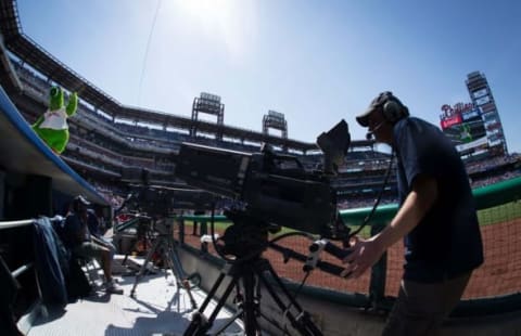 May 14, 2015; Philadelphia, PA, USA; The Phillie Phanatic dances on the dugout as a TV cameraman watches on during a game between the Philadelphia Phillies and the Pittsburgh Pirates at Citizens Bank Park. The Phillies won 4-2. Mandatory Credit: Bill Streicher-USA TODAY Sports