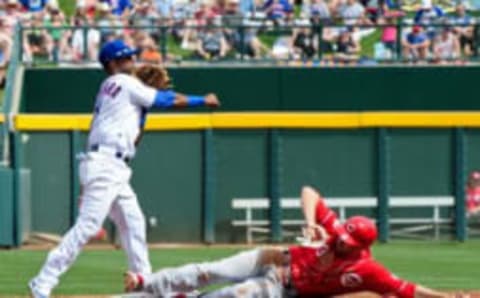 Mar 5, 2016; Mesa, AZ, USA; Chicago Cubs second baseman Arismendy Alcantara (7) turns a double play on Cincinnati Reds center fielder Jake Cave (30) in the third inning at Sloan Park. Mandatory Credit: Matt Kartozian-USA TODAY Sports