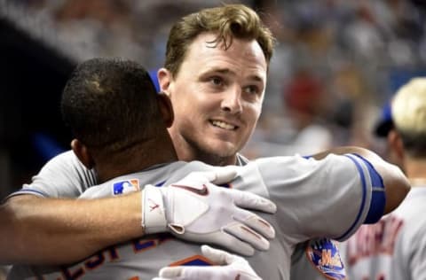 Sep 28, 2016; Miami, FL, USA; New York Mets right fielder Jay Bruce (right) is greeted by left fielder Yoenis Cespedes (left) in the dugout after Bruce hit a two run homer during the fifth inning against the Miami Marlins at Marlins Park. The Mets won 5-2. Mandatory Credit: Steve Mitchell-USA TODAY Sports