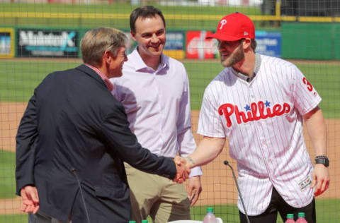 CLEARWATER, FL – MARCH 2: John Middleton, Philadelphia Phillies managing parter, shakes hands with Bryce Harper as general manager Matt Klentak looks on during the press conference introducing Harper as a member of the Philadelphia Phillies on Saturday March 2, 2019 at Spectrum Field in Clearwater, Florida. (Photo by Mike Carlson/MLB via Getty Images)