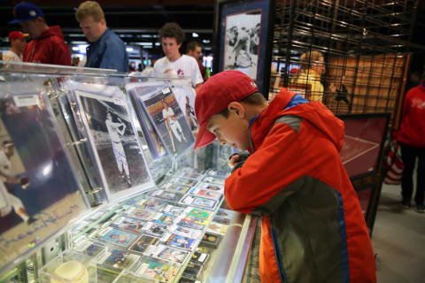 PHILADELPHIA, PA – MAY 12: A young boy looks at a display of baseball cards during a rain delay before a game between the Philadelphia Phillies and the New York Mets at Citizens Bank Park on May 12, 2018 in Philadelphia, Pennsylvania. The game was later postponed due to weather. (Photo by Hunter Martin/Getty Images)