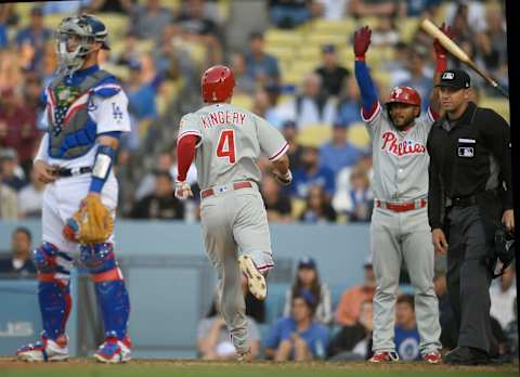 LOS ANGELES, CA – MAY 31: Yasmani Grandal of the Los Angeles Dodgers stands at the plate while Scott Kingery #4 of the Philadelphia Phillies scores a run in the seventh inning as Jesmuel Valentin #9 signals to stand at Dodger Stadium on May 31, 2018 in Los Angeles, California. (Photo by John McCoy/Getty Images)