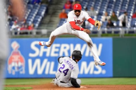 Apr 25, 2022; Philadelphia, Pennsylvania, USA; Philadelphia Phillies first baseman Johan Camargo (7) leaps out of the way after getting force out on Colorado Rockies second baseman Ryan McMahon (24) during the seventh inning at Citizens Bank Park. Mandatory Credit: Eric Hartline-USA TODAY Sports