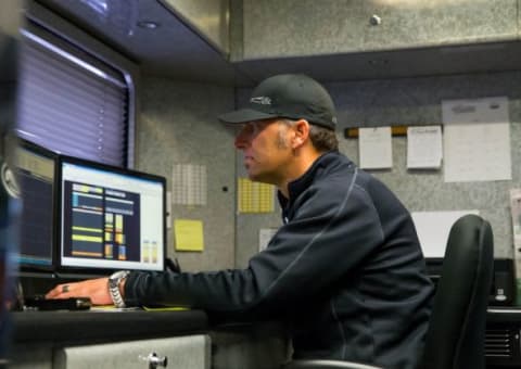 Jun 7, 2015; Englishtown, NJ, USA; Aaron Brooks , crew chief for NHRA top fuel driver Morgan Lucas (not pictured) works on a computer in the teams hauler lounge in the pits during the Summernationals at Old Bridge Township Raceway Park. Mandatory Credit: Mark J. Rebilas-USA TODAY Sports