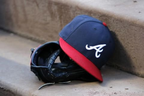 Aug 25, 2015; Atlanta, GA, USA; Detailed view of Atlanta Braves hat and glove in the dugout before a game against the Colorado Rockies at Turner Field. Mandatory Credit: Brett Davis-USA TODAY Sports