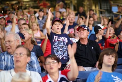 Jul 21, 2014; Atlanta, GA, USA; Atlanta Braves fan Maddox Lee (7 years old), from Greenwood, S.C., does the tomahawk chop during the game against the Miami Marlins at Turner Field. The Marlins won 3-1 in extra innings. Mandatory Credit: Kevin Liles-USA TODAY Sports