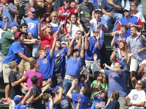 Aug 23, 2015; Chicago, IL, USA; Fans reach for the home run ball hit by Atlanta Braves catcher Ryan Lavarnway (not pictured) during the fifth inning against the Chicago Cubs at Wrigley Field. Mandatory Credit: Dennis Wierzbicki-USA TODAY Sports